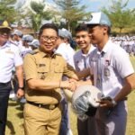 Bupati Adi Arnawa menyerahkan helm kepada pelajar SMAN 2 Abiansemal