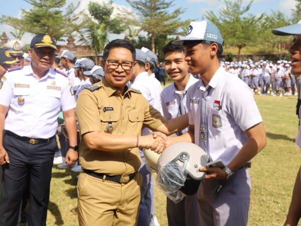 Bupati Adi Arnawa menyerahkan helm kepada pelajar SMAN 2 Abiansemal