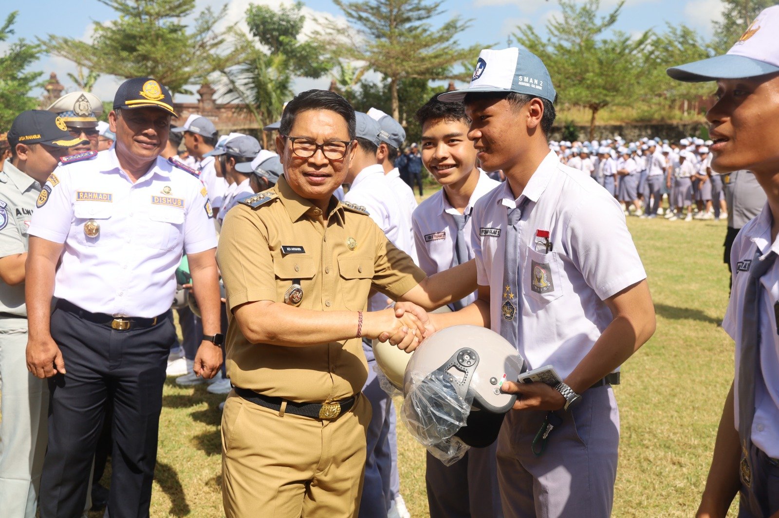 Bupati Adi Arnawa menyerahkan helm kepada pelajar SMAN 2 Abiansemal